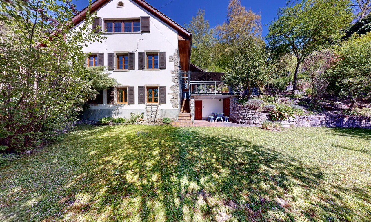 view of property with a lawn, stucco siding, and a wooden deck