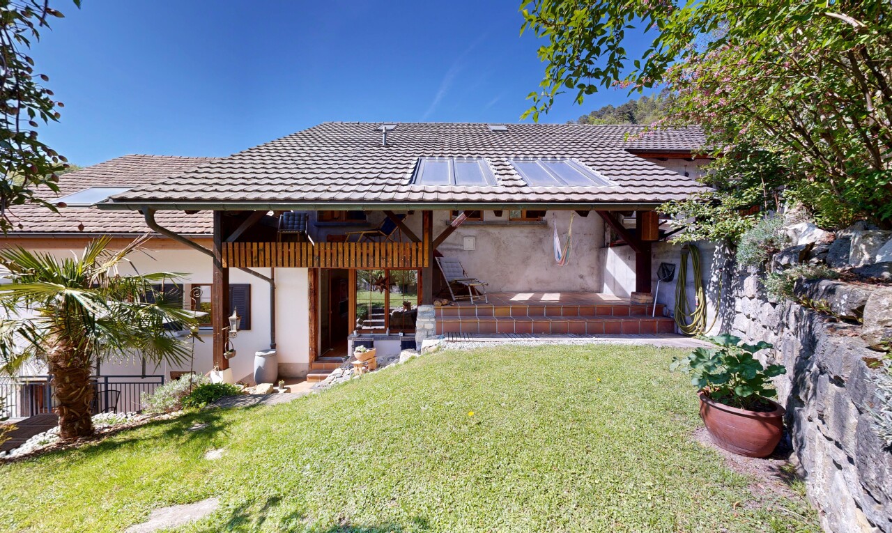 view of home with a lawn, a tile roof, stucco siding, and solar panels