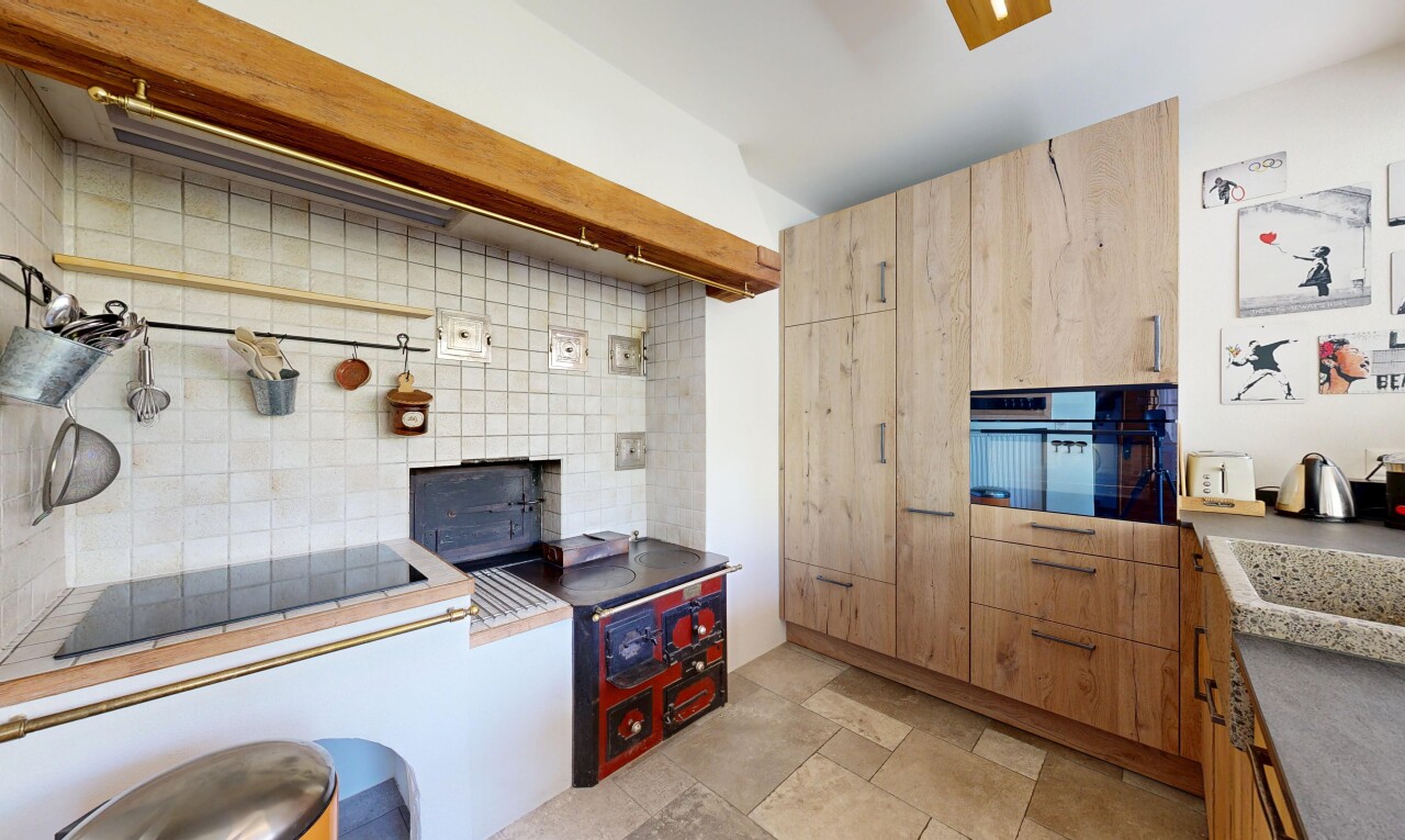 kitchen featuring decorative backsplash, black appliances, and light wood finish cabinets