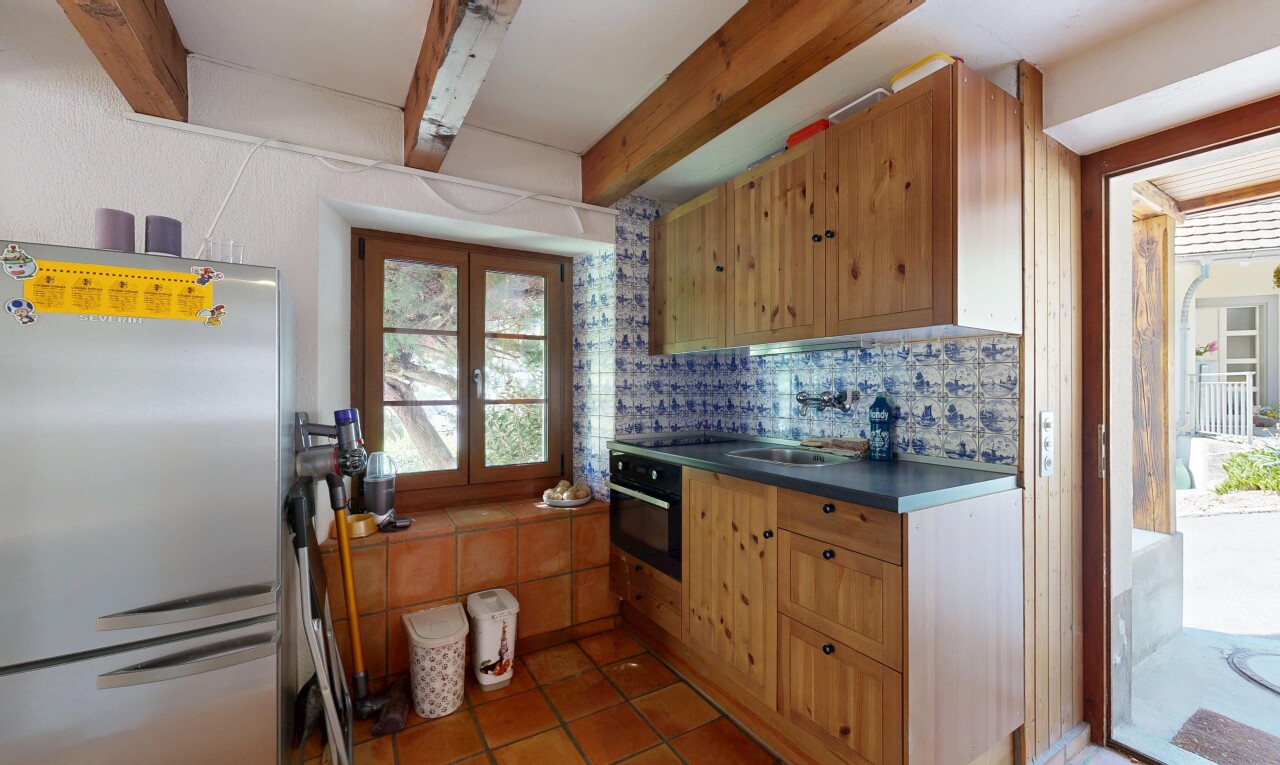 kitchen featuring freestanding refrigerator, oven, dark countertops, tasteful backsplash, and beamed ceiling