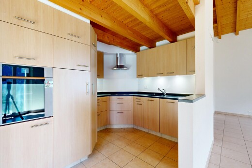 cuisine avec armoires marron clair, light brown cabinets, four, plans de travail, et dark countertops