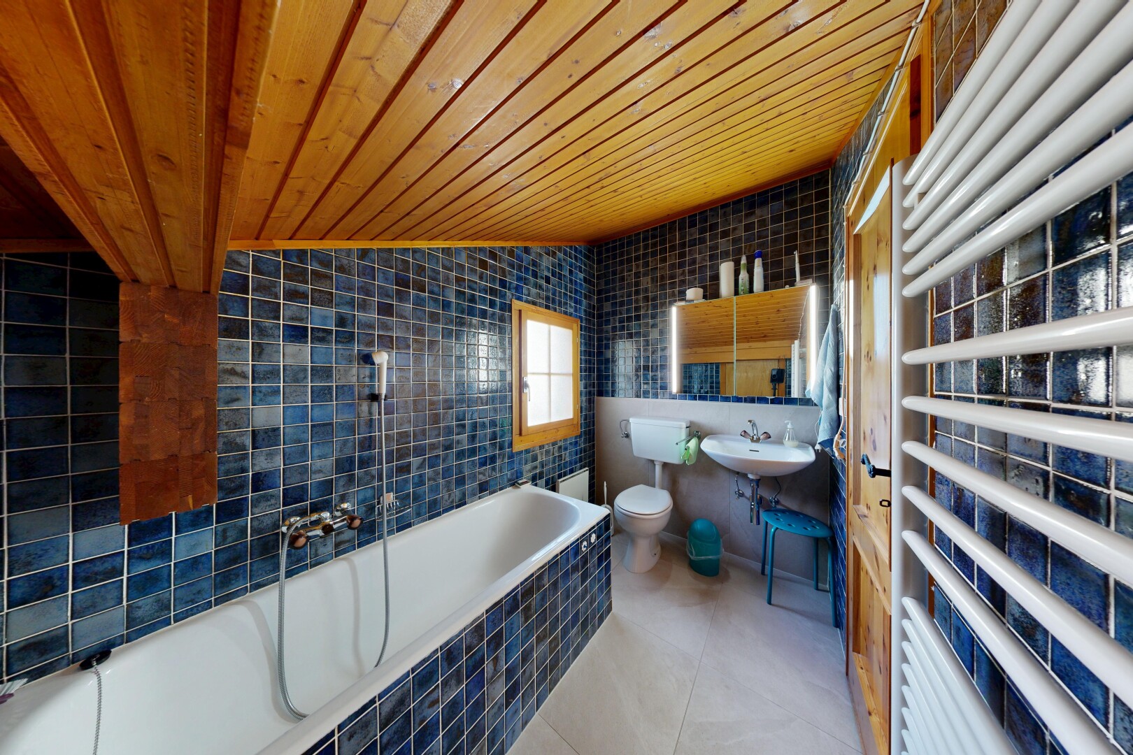 salle de bains avec chauffe-serviettes, tile wall, mur en carrelage, wood ceiling, et plafond en bois
