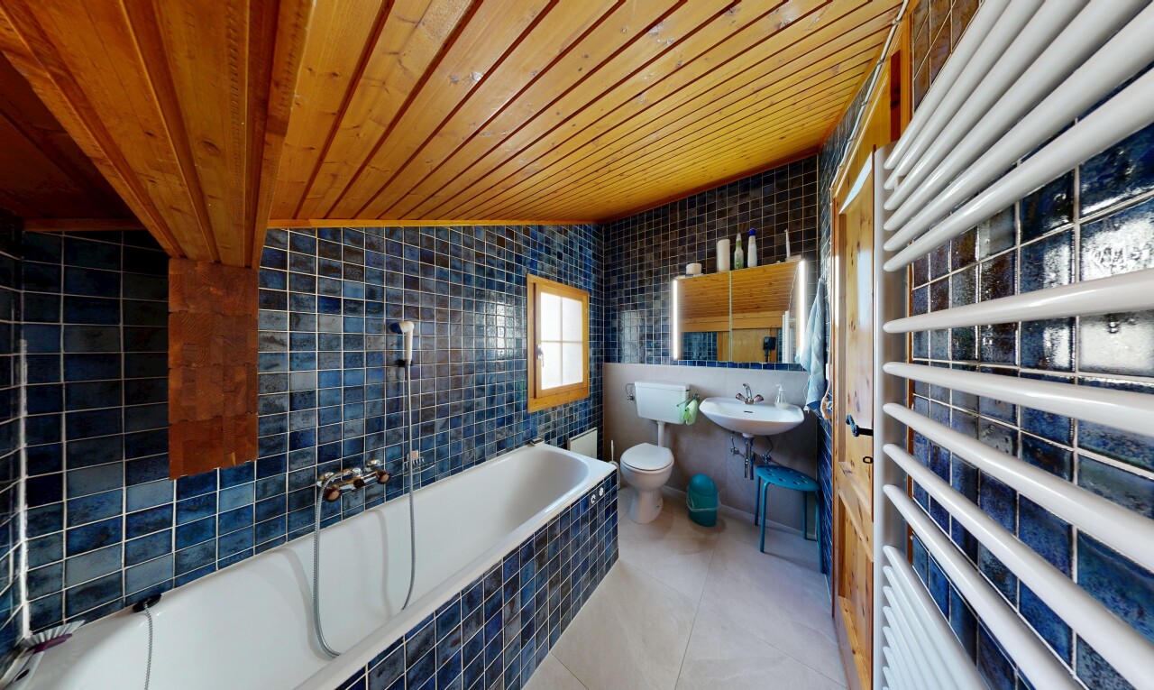salle de bains avec chauffe-serviettes, tile wall, mur en carrelage, wood ceiling, et plafond en bois