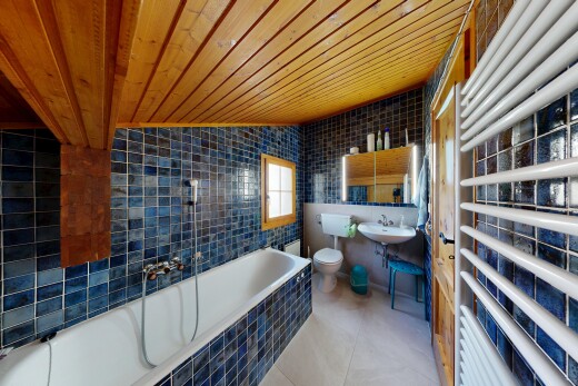 salle de bains avec chauffe-serviettes, tile wall, mur en carrelage, wood ceiling, et plafond en bois
