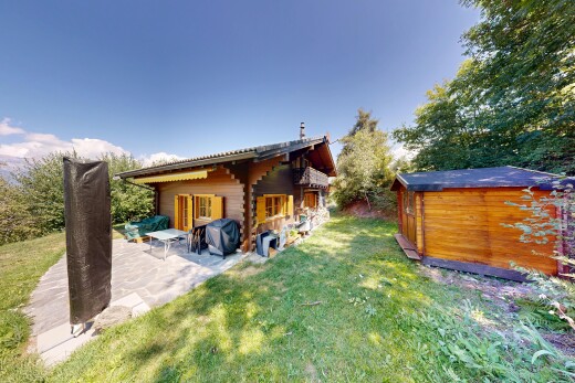 view of home with a yard, a storage unit, and a patio area