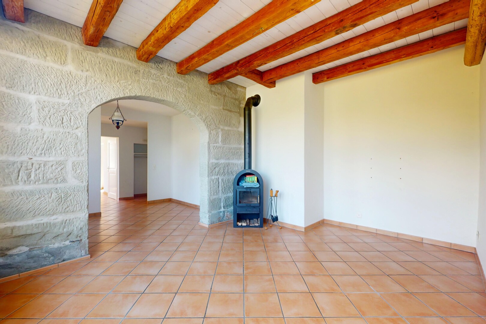 leerer raum mit holzofen, gewölbte gehwege, fliesenboden, tile floor, und inside property