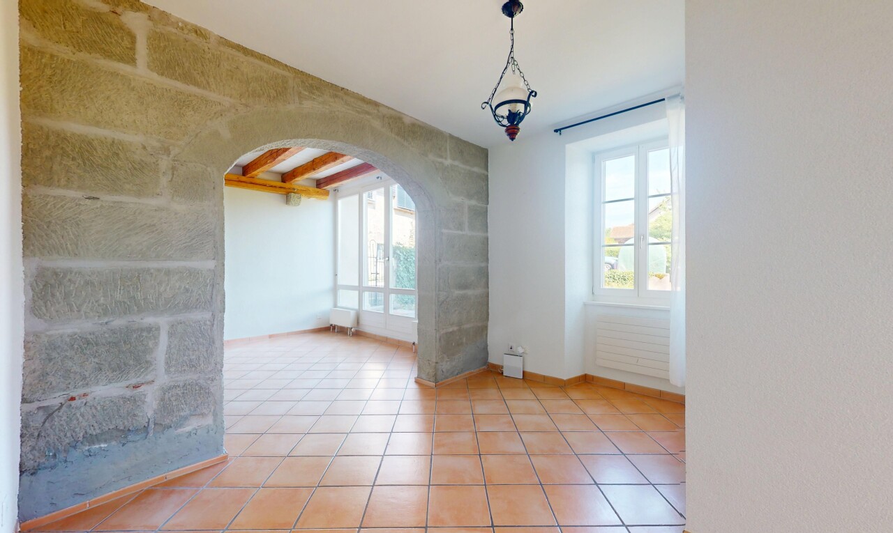 leerer raum mit gewölbte gehwege, natural light, natürliches licht, inside property, und tile floor