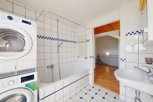 salle de bains avec tile tub, lave-linge et sèche-linge superposés, inside property, sol en carrelage, et tile floor