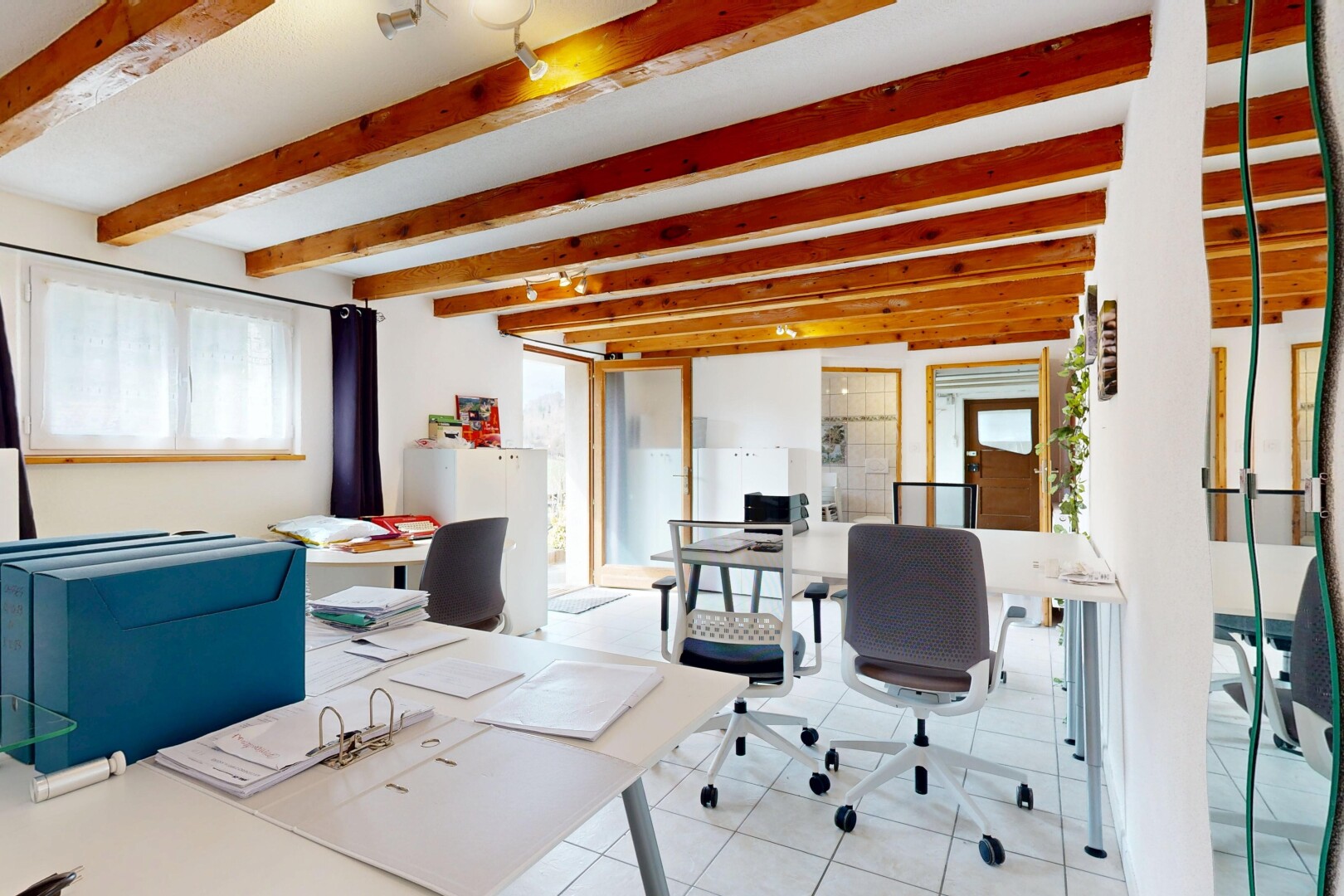 bureau avec cloison sèche, lumière naturelle, sol en carrelage, et plafond à poutres