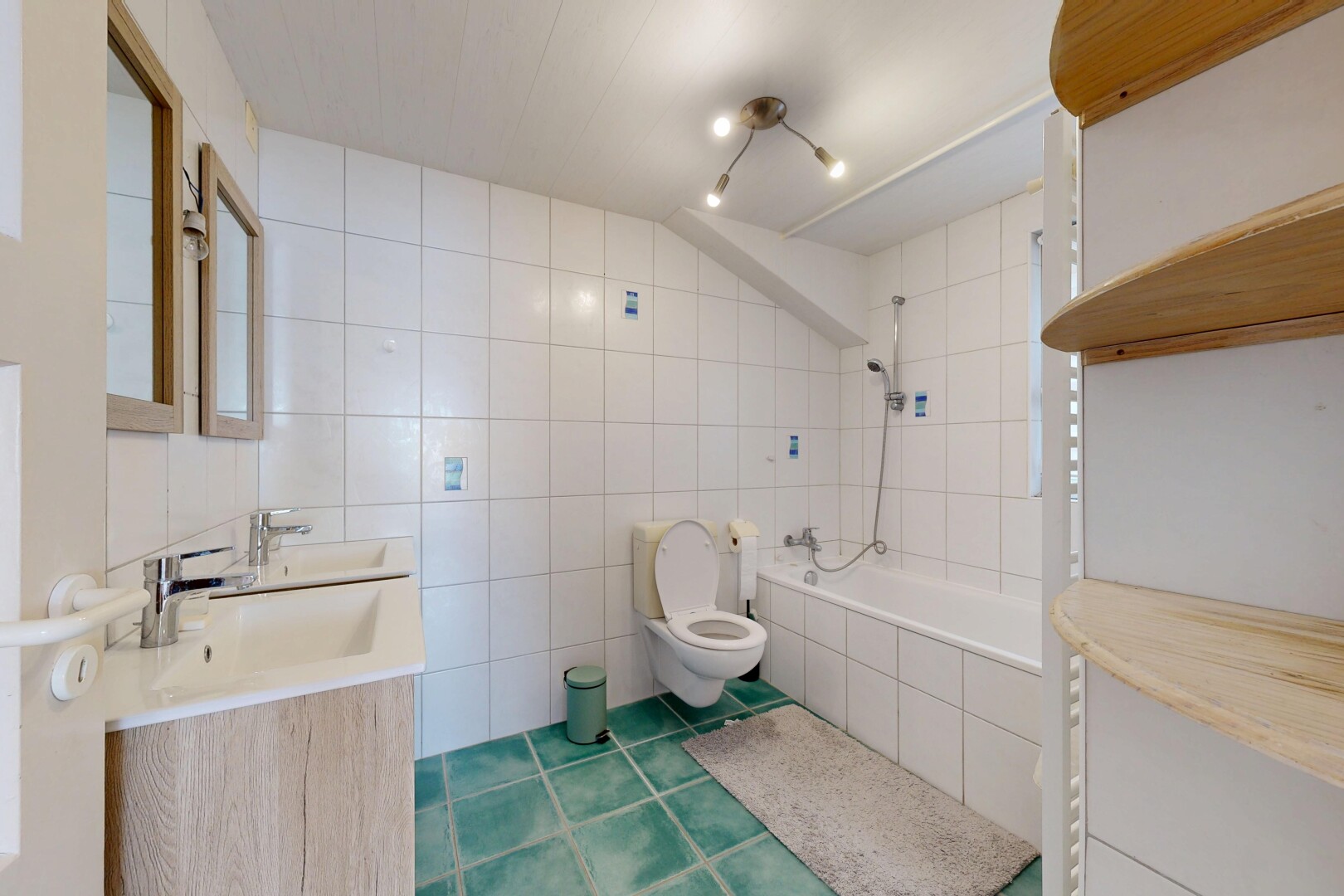 salle de bains avec salle de bain complète, toilette, évier, douche-bain combinés, et mur en carrelage