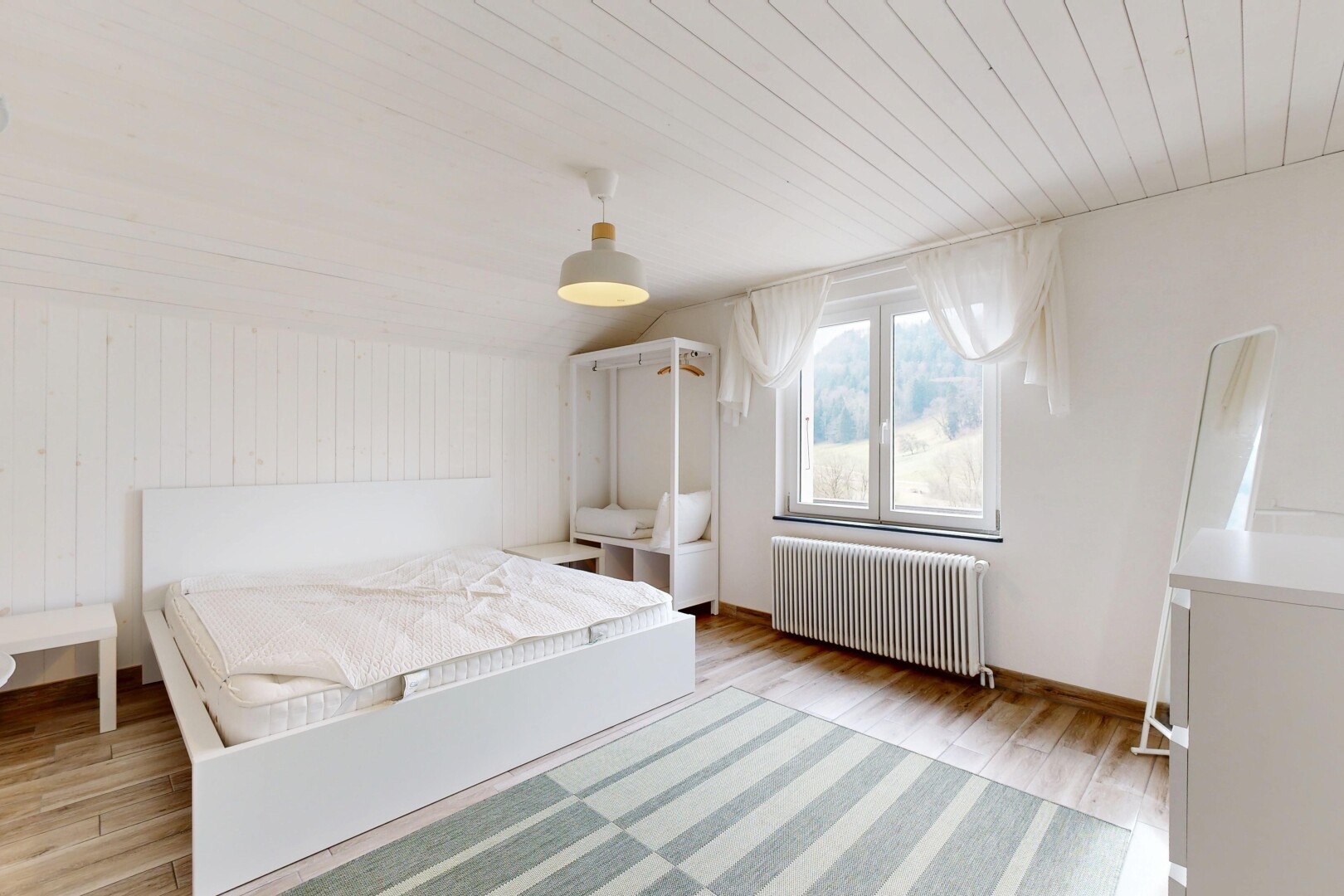 chambre avec plafond voûté, radiateur, lumière naturelle, plafond en bois, et sol en finition bois
