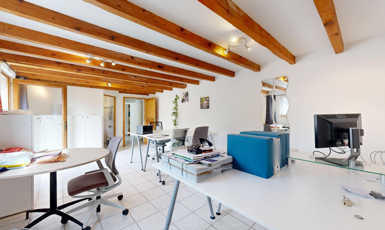 bureau avec sol en carrelage, plafond à poutres, cloison sèche, et télévision