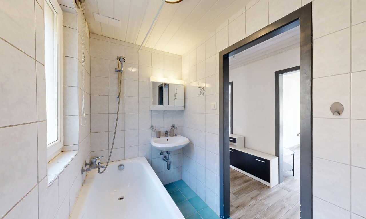 salle de bains avec douche-bain combinés, salle de bain complète, mur en carrelage, et miroir