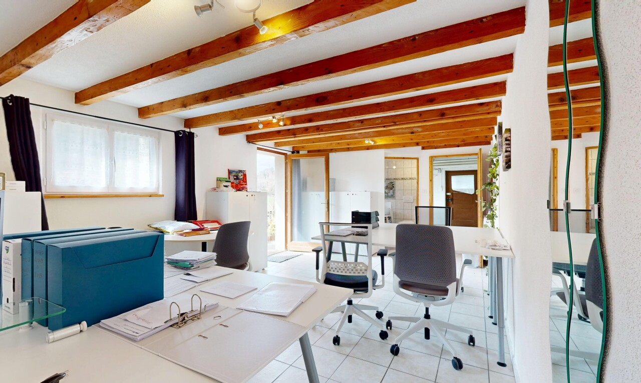 bureau avec cloison sèche, lumière naturelle, sol en carrelage, et plafond à poutres