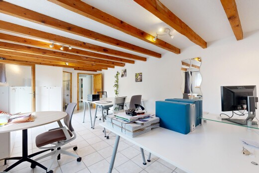bureau avec sol en carrelage, plafond à poutres, cloison sèche, et télévision