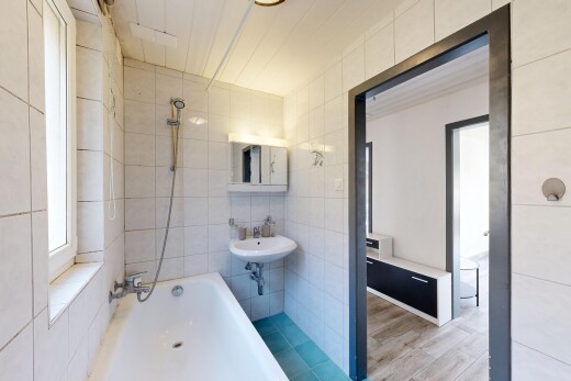 salle de bains avec douche-bain combinés, salle de bain complète, mur en carrelage, et miroir