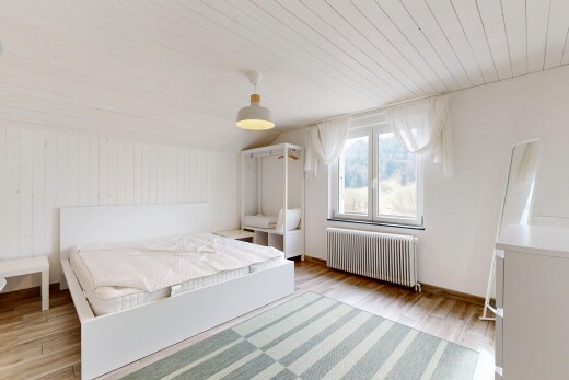 chambre avec plafond voûté, radiateur, lumière naturelle, plafond en bois, et sol en finition bois