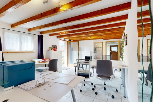 bureau avec cloison sèche, lumière naturelle, sol en carrelage, et plafond à poutres