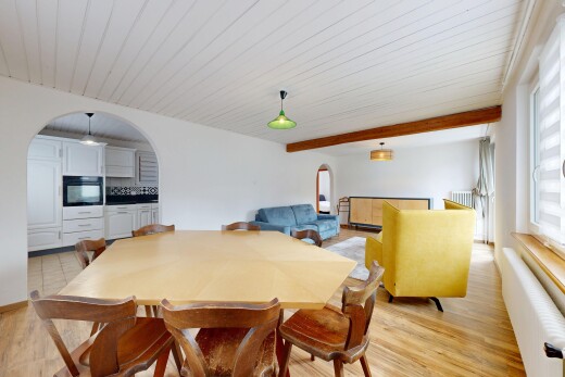 esszimmer mit gewölbte gehwege, natürliches licht, gipskartonwand, und holzfußboden