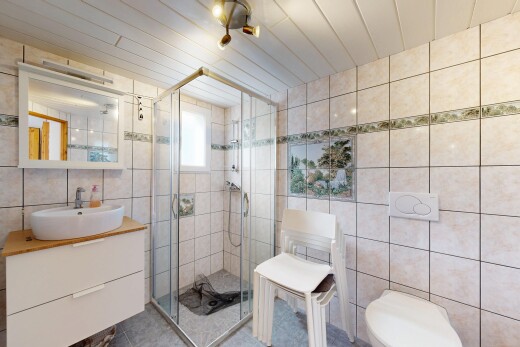 salle de bains avec évier, douche, mur en carrelage, et lavabo (ou coiffeuse selon le contexte)