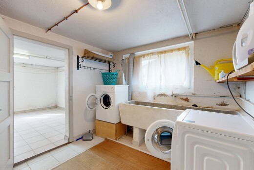 buanderie avec lumière naturelle, cloison sèche, sol en carrelage, buanderie, et lave-linge et sèche-linge séparés