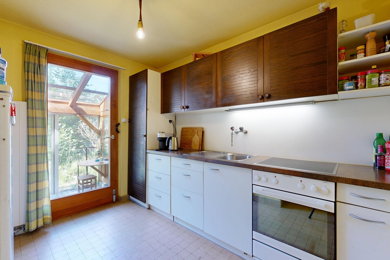 kitchen featuring oven, light flooring, black electric cooktop, open shelves, and dark countertops