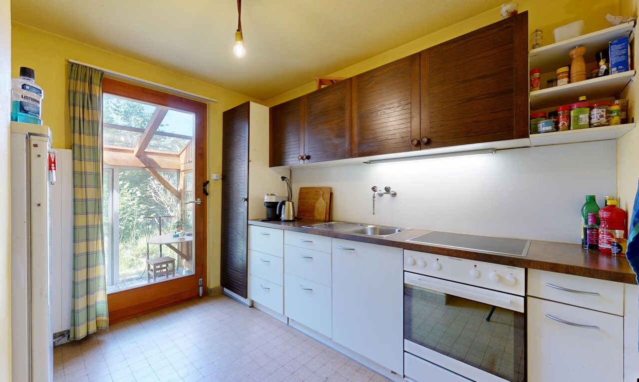 kitchen featuring oven, light flooring, black electric cooktop, open shelves, and dark countertops