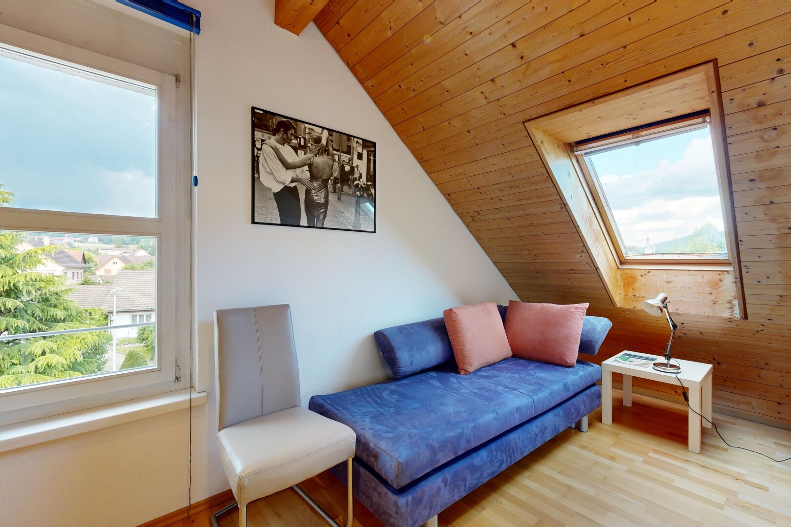 wohnzimmer mit inside property, dachschräge, vaulted ceiling, day time, und holzfußboden