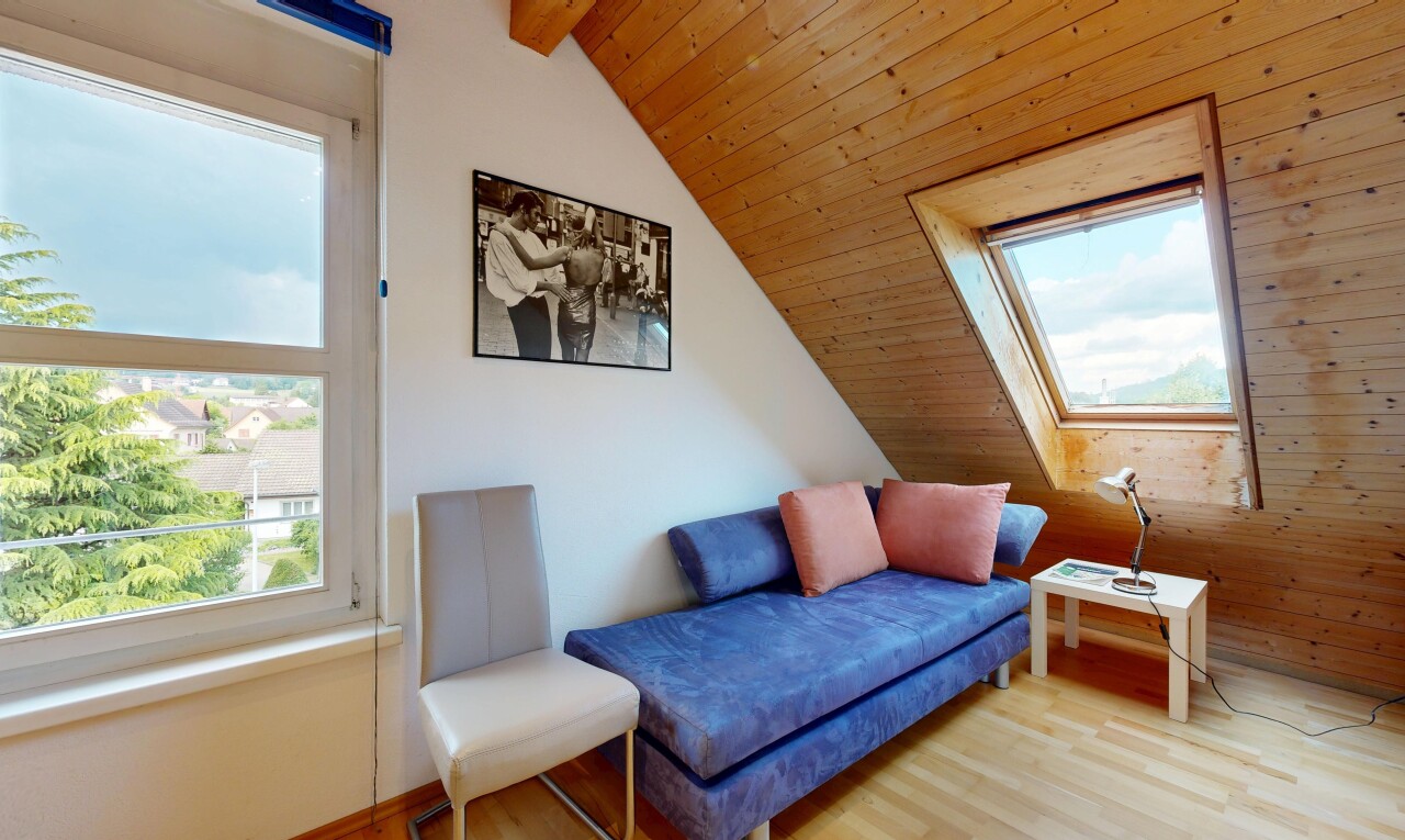 wohnzimmer mit inside property, dachschräge, vaulted ceiling, day time, und holzfußboden