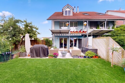 view of property featuring a balcony, a fenced backyard, a tile roof, a patio area, and outdoor seating
