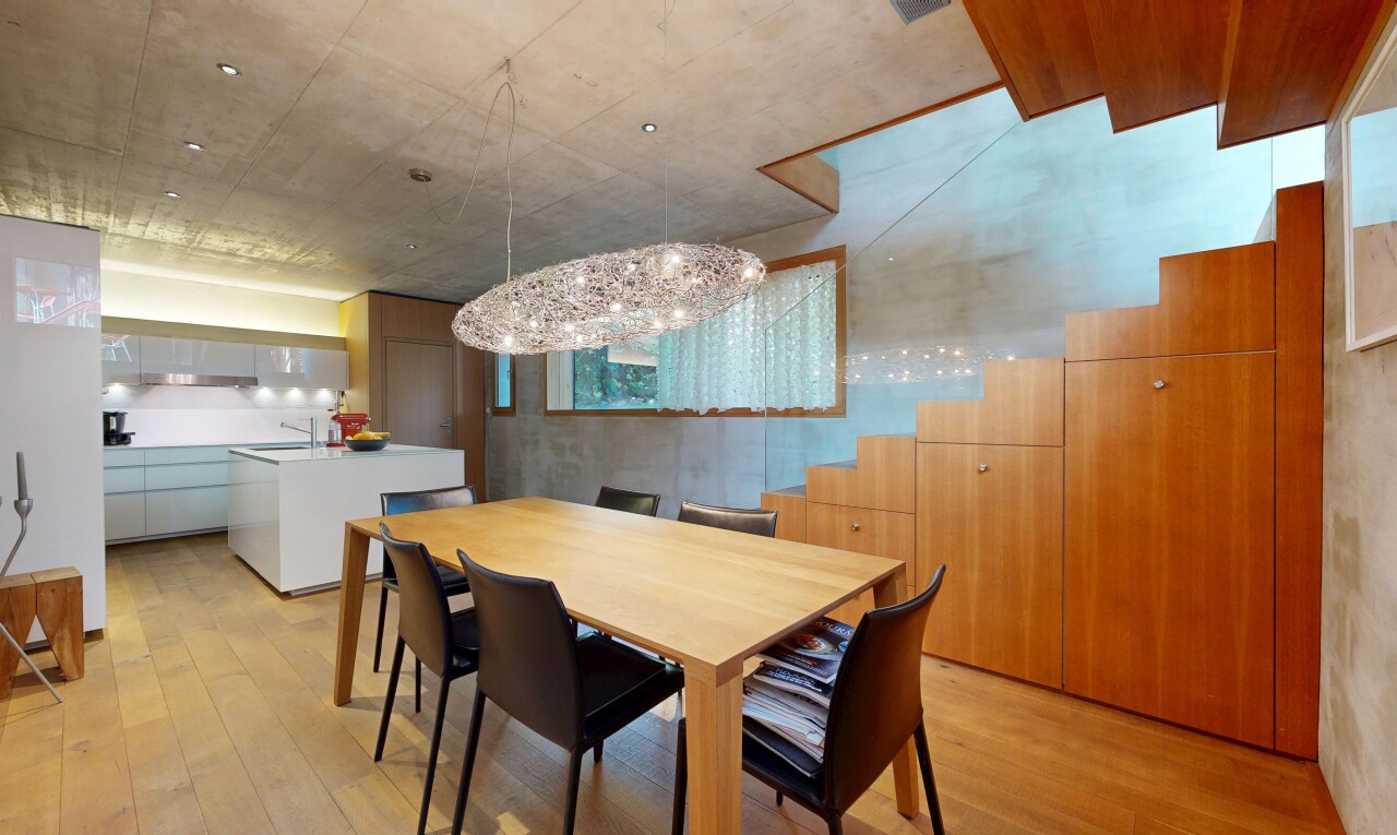 esszimmer mit bemerkenswerter kronleuchter, holzfußboden, wood finish floor, betondecke, und concrete ceiling