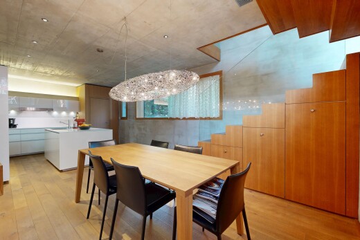 salle à manger avec lustre remarquable, sol en finition bois, wood finish floor, plafond en béton, et concrete ceiling