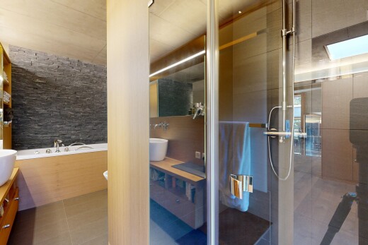 salle de bains avec lavabo (ou coiffeuse selon le contexte), salle de bain complète, miroir, douche, et bain