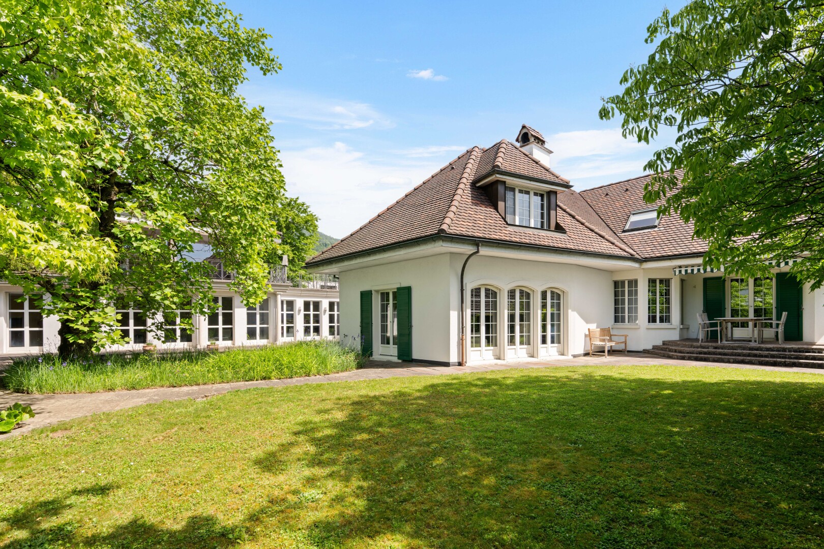 außenansicht mit rasen, property visible, stuckverkleidung, day time, und französische türen