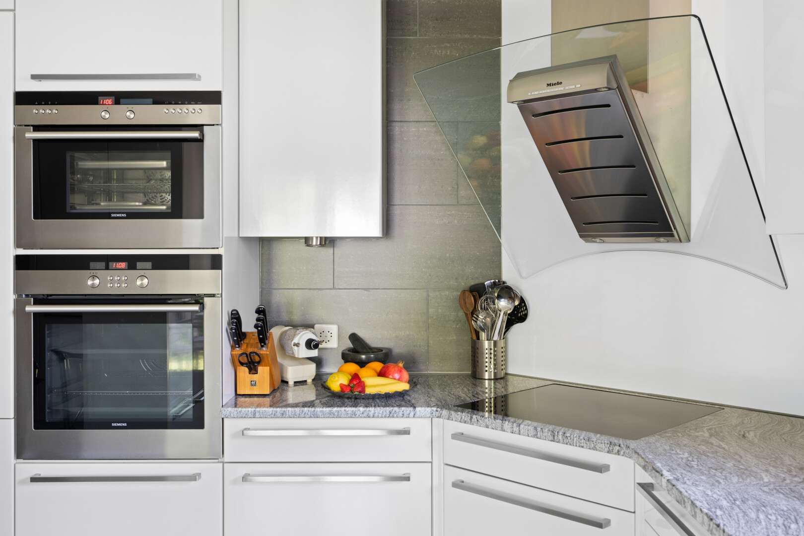 küche mit weiße schränke, white cabinets, dunstabzugshaube, doppel backofen, und stein arbeitsplatten
