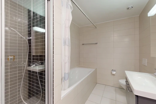 salle de bains avec douche, salle de bain complète, mur en carrelage, tile wall, et lavabo (ou coiffeuse selon le contexte)