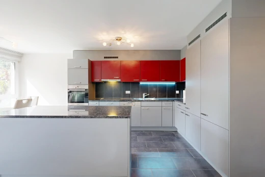 cuisine avec two tone kitchen, dark floor, dark countertops, red cabinets, et armoires rouges