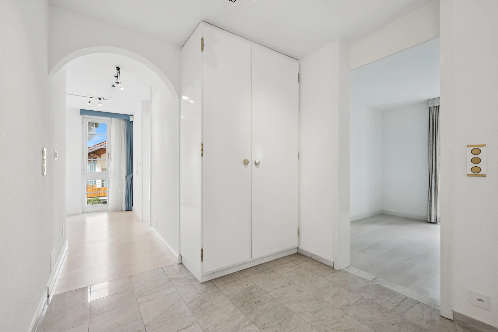 halle / korridor mit gewölbte gehwege, light floor, gipskartonwand, drywall, und inside property