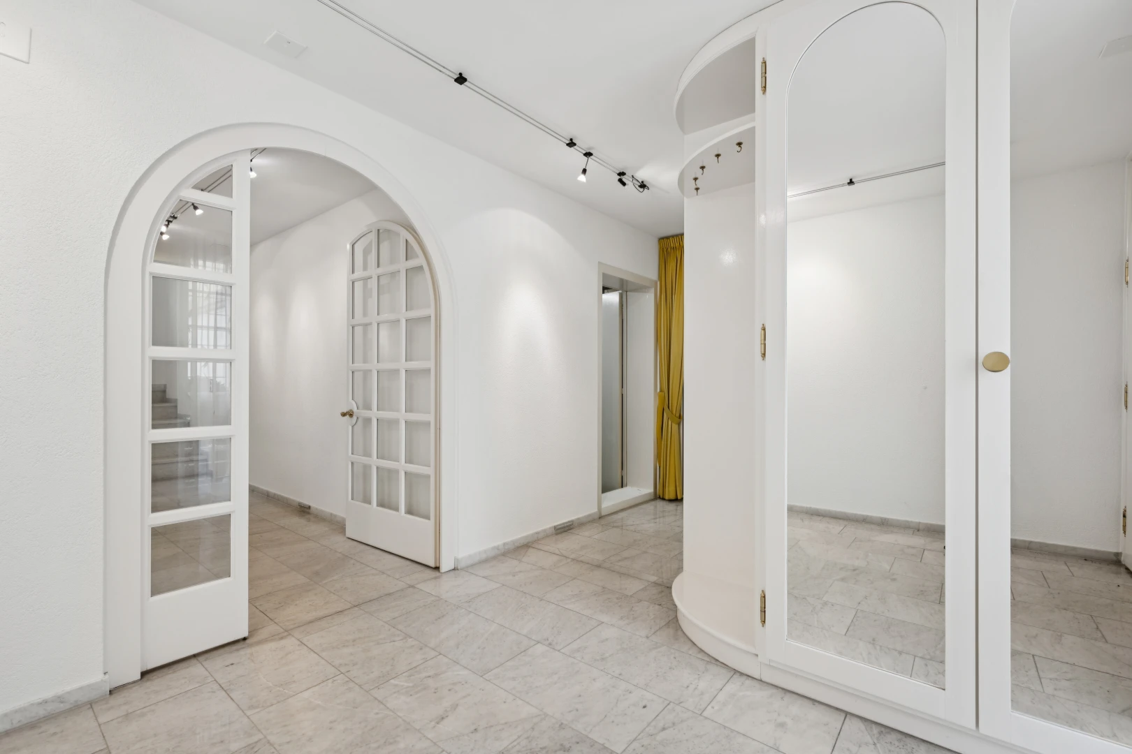 halle / korridor mit gewölbte gehwege, light floor, gipskartonwand, drywall, und inside property