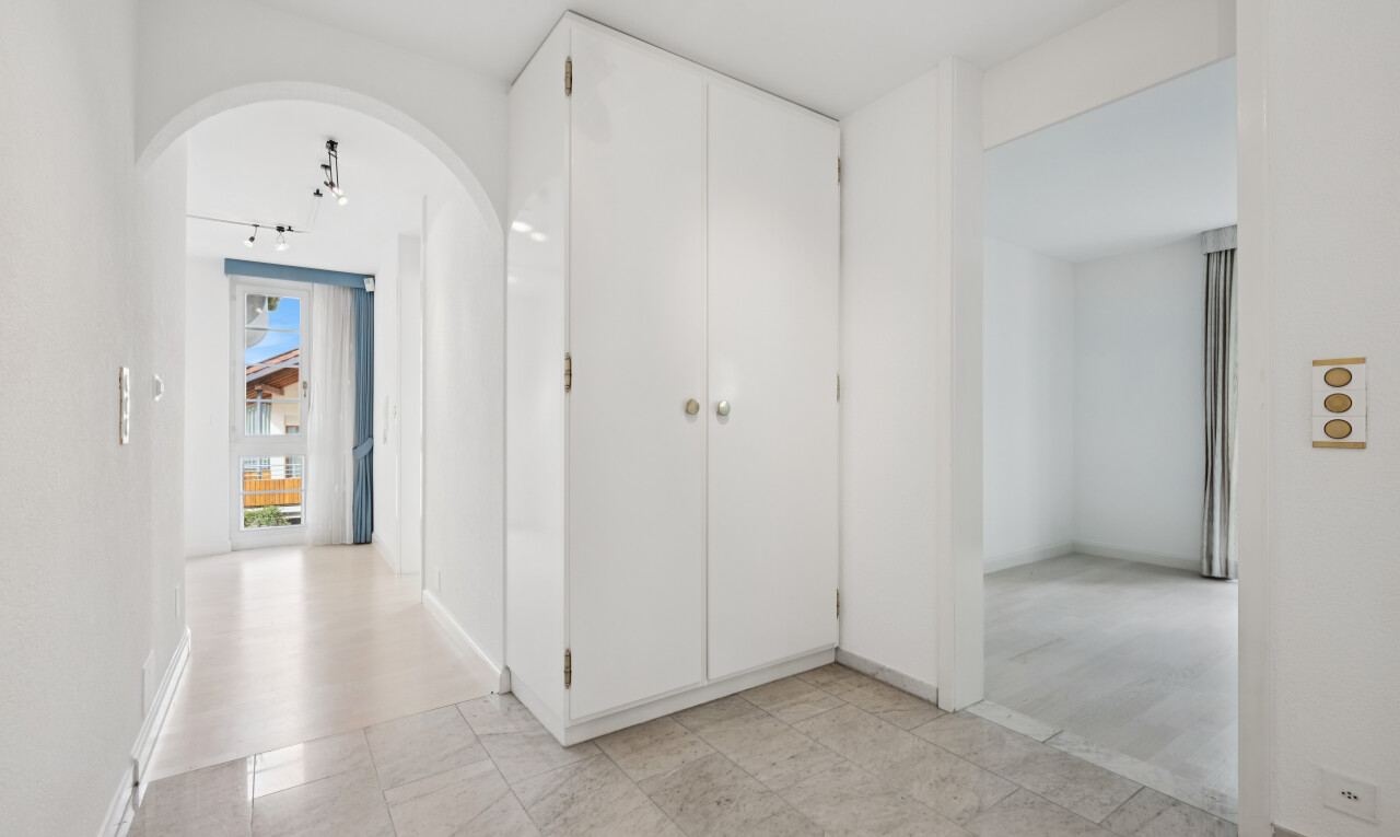 halle / korridor mit gewölbte gehwege, light floor, gipskartonwand, drywall, und inside property