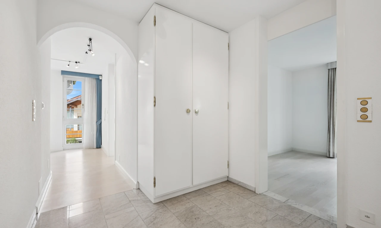 halle / korridor mit gewölbte gehwege, light floor, gipskartonwand, drywall, und inside property
