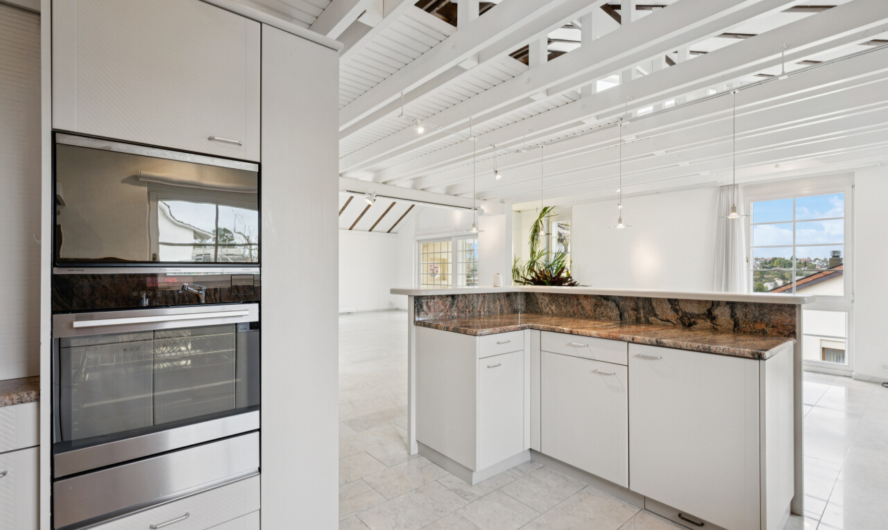 küche mit weiße schränke, white cabinets, dark countertops, two heights countertops, und doppel backofen