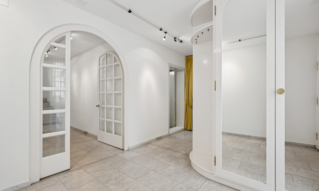 halle / korridor mit gewölbte gehwege, light floor, gipskartonwand, drywall, und inside property