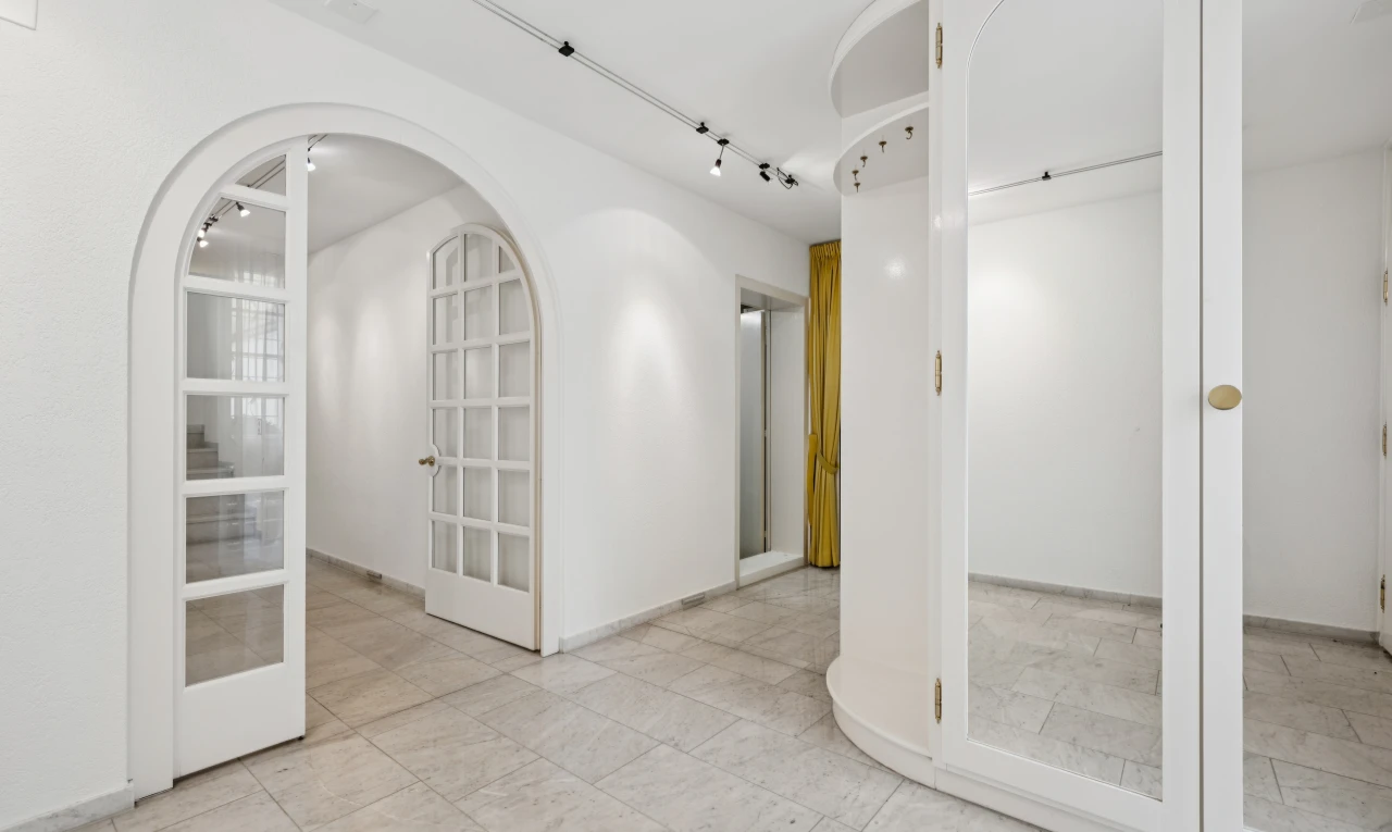 halle / korridor mit gewölbte gehwege, light floor, gipskartonwand, drywall, und inside property