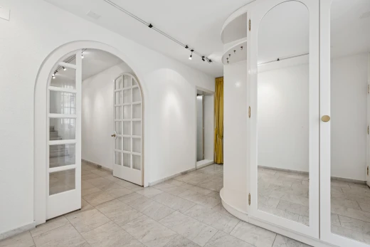 halle / korridor mit gewölbte gehwege, light floor, gipskartonwand, drywall, und inside property