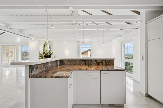 küche mit dark countertops, weiße schränke, white cabinets, two heights countertops, und kücheninsel