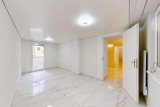 spare room with light marble finish flooring and radiator