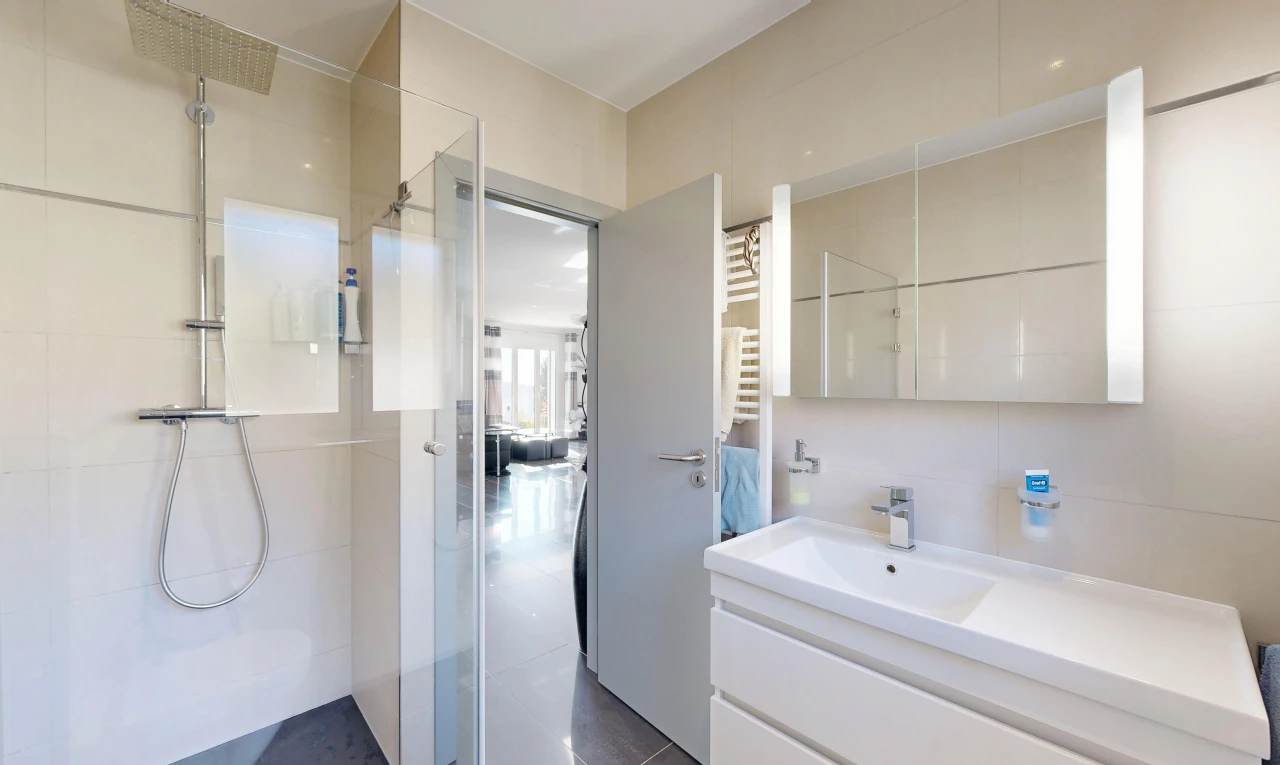 salle de bains avec douche, salle de bain complète, lavabo (ou coiffeuse selon le contexte), évier, et chauffe-serviettes