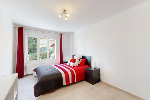 chambre avec radiateur, drywall, cloison sèche, light floor, et wood finish floor