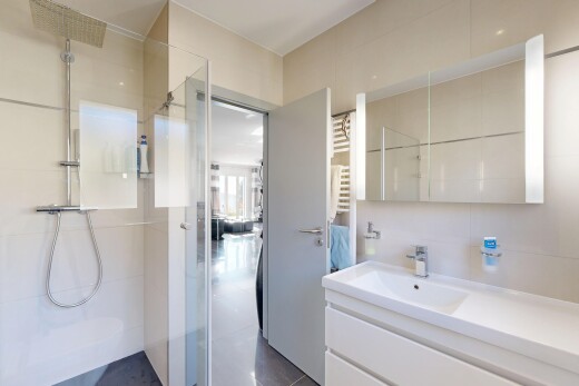 salle de bains avec douche, salle de bain complète, lavabo (ou coiffeuse selon le contexte), évier, et chauffe-serviettes